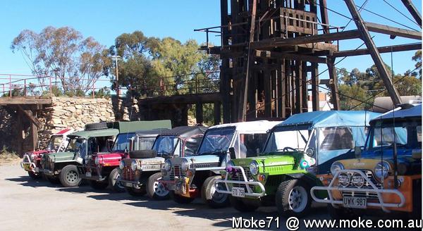 A picture of Mokes lined up next to old minig equipment in Broken Hill
