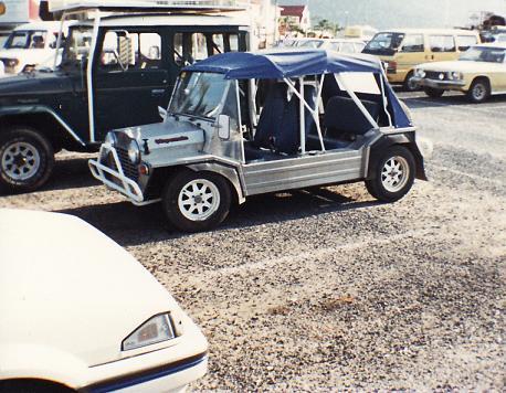 A stainless steel Super Moke in a shoppiong centre carpark in 1989.